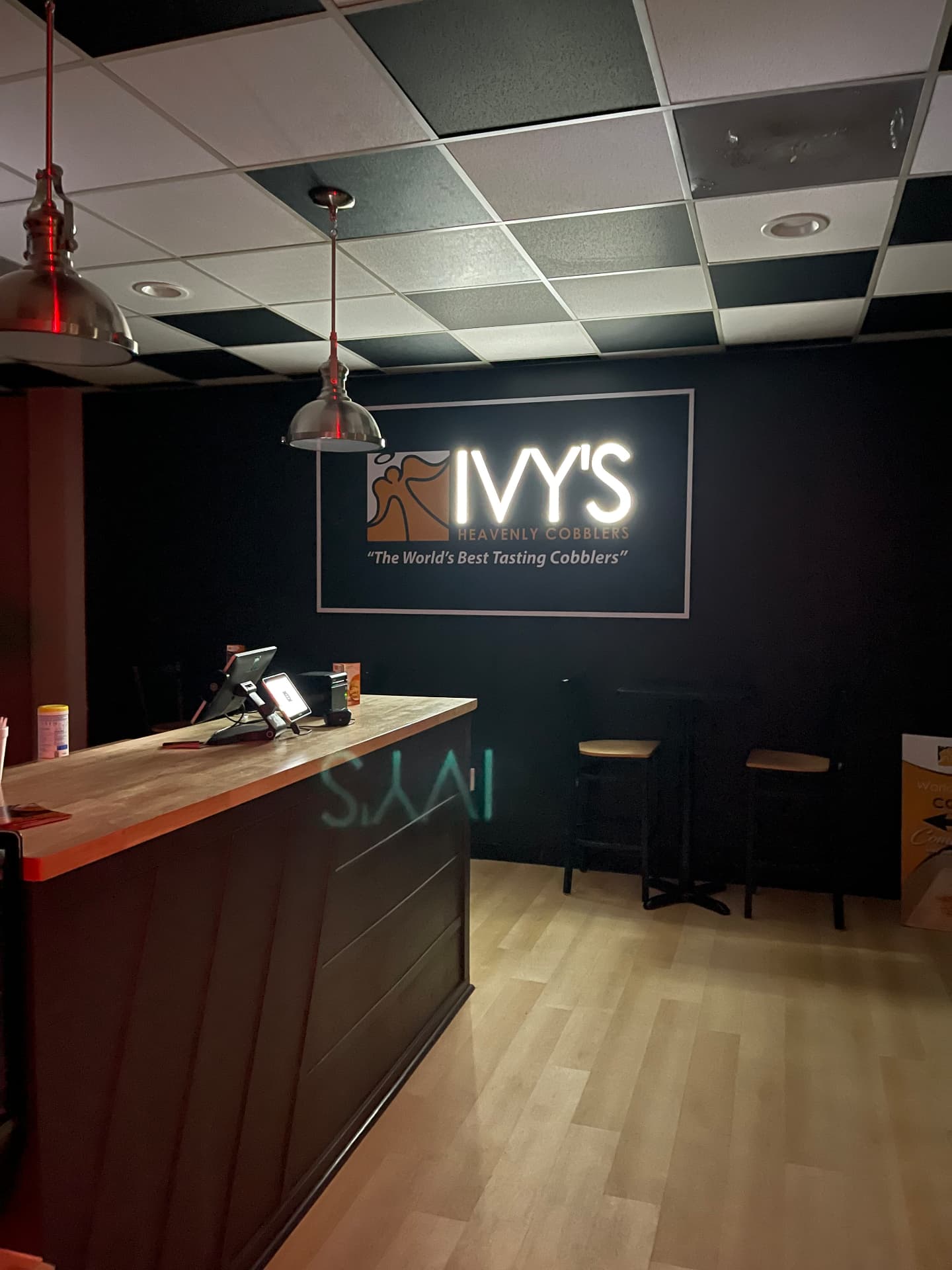 Inside Ivy's Heavenly Cobblers, counter and illuminated logo wall