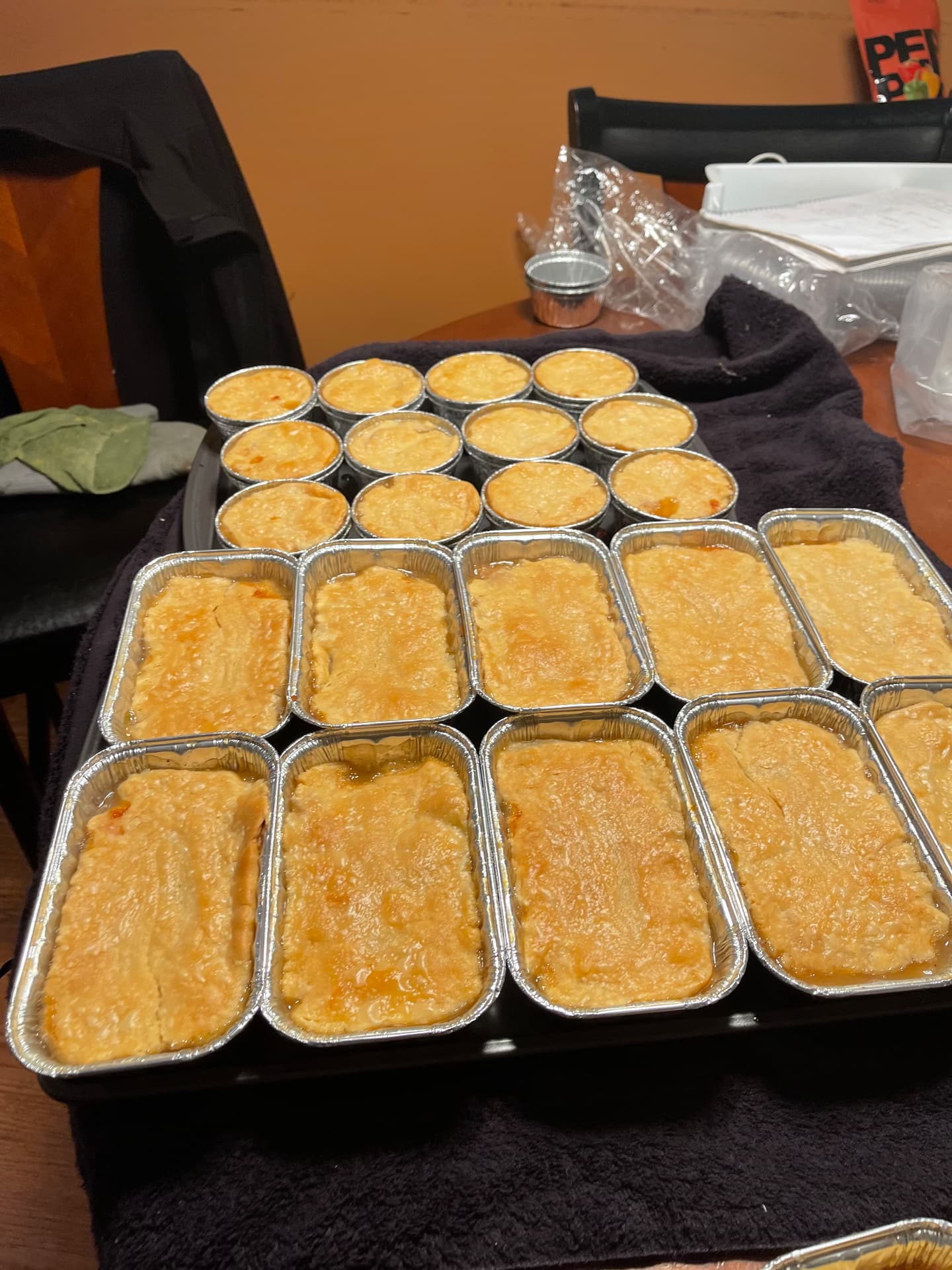 Trays of freshly baked peach cobblers in single-serve cups and loaf pans